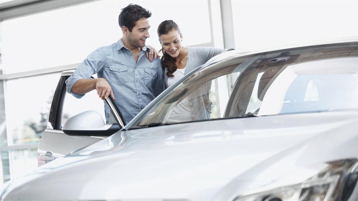 A happy couple feeling satisfied looking at the Renault car